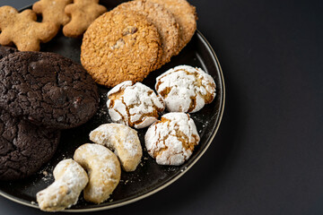 homemade chocolate oatmeal cookies sprinkled with sugar on a black background in a black plate