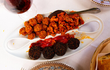 Traditional hot Spanish tapa of blood sausage, chorizo, picadillo and roasted peppers