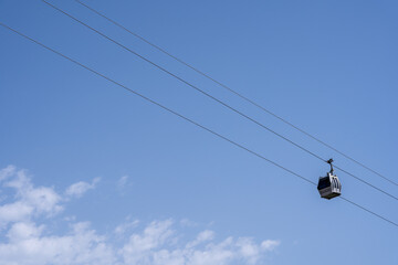 a small gray cable car with diagonal blue skies