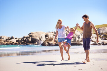 Enjoying the beach together. Shot of a happy young family taking a walk on the beach.