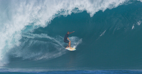 Surfer surfing big ocean barrel tube wave at Pipeline in north shore of Hawaii's Oahu island pro...