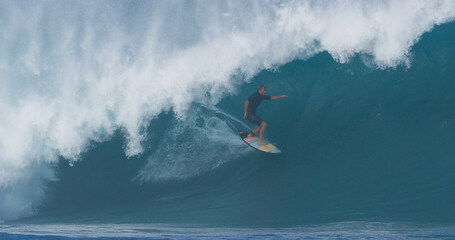 Surfer surfing big ocean barrel tube wave at Pipeline in north shore of Hawaii's Oahu island pro surfer Anthony Walsh