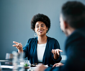 Any thoughts. Cropped shot of an attractive young businesswoman talking to her colleagues during a meeting in the boardroom.