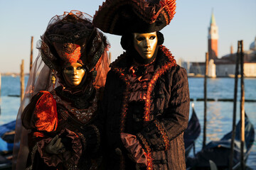 Obraz na płótnie Canvas Venice, Italy - February 2022 - carnival masks are photographed with tourists in San Marco square
