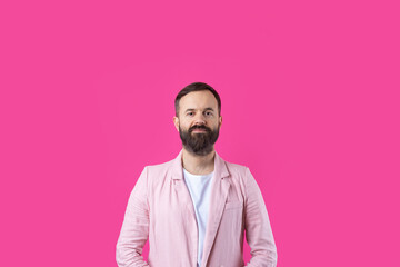 Handsome man with a beard in a pink jacket is thinking over an isolated red background.