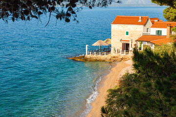Beautiful view on small restaurant on the Adriatic sea pebble beach, Bol, Brac island, Croatia