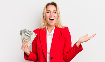 blonde pretty woman feeling happy and astonished at something unbelievable