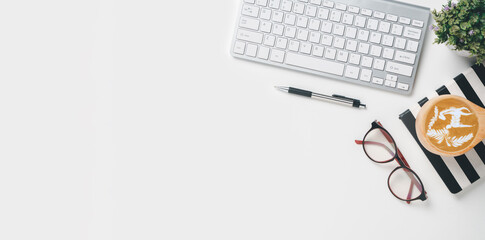 Office desk with keyboard computer, Pen, notebook, Cup of coffee, eyeglass on white background, Top view with copy space, Mock up....