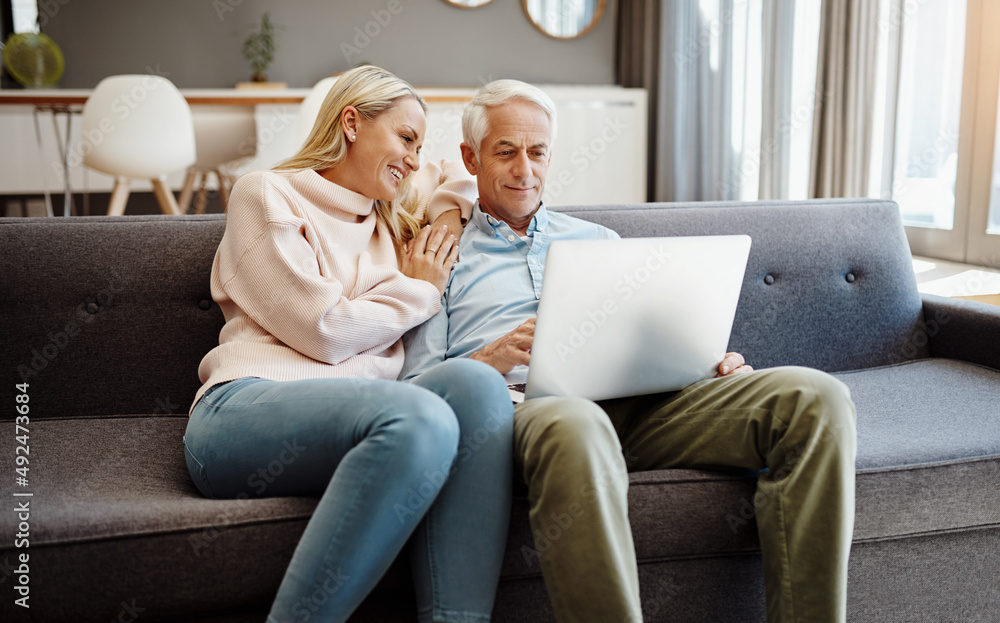 Poster The easiest way to stay relevant. Shot of a mature couple using a laptop on the sofa at home.