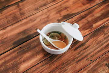 Fish sauce with chili in a white cup on Wooden table background. popular Side dish any thai food. Soft focus, Select focus