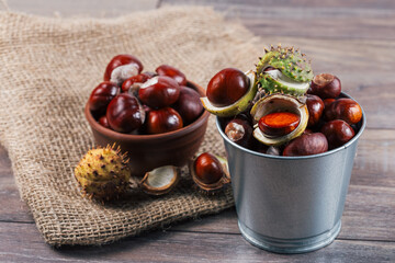 Close up view of chestnuts in a metal basket on a wooden background