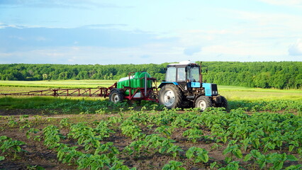agricultural machine sprays herbicides large field of sunflowers on a sunny day