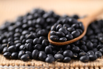 Black soybean seeds in wooden spoon, Food ingredients