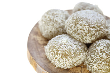 mochi cakes.Coconut mochi on a wooden round board on white background. Japanese traditional dessert with coconut. 