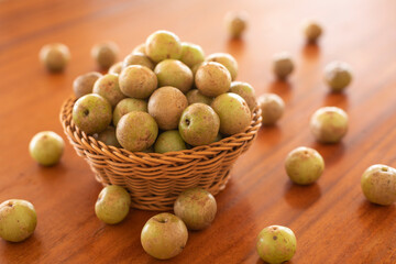 Indian Gooseberry full in basket place on wooden table