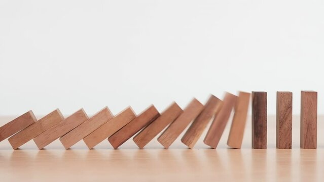 Slow motion, Domino effect made up from wooden blocks shape toy on wooden desk, domino effect in business concept,  Risk protection concept.