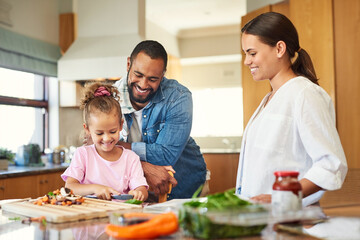 Food just taste better when its made with love. Shot of a couple and their daughter cooking...