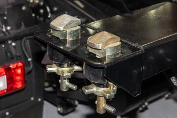 Two new Twistlocks on a semi-trailer frame. Twistlock in close-up. Transporting shipping containers on trucks on the road