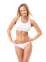 Fototapeta premium Shes pretty and poised in all her perfection. A gorgeous young woman in sporty lingerie posing with hands on her hips against a white background.