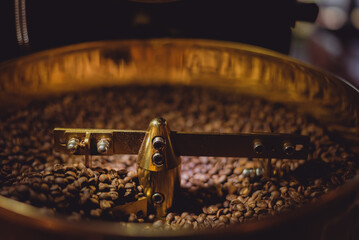 Golden coffee roaster machine in a medium-sized industrial roaster, Roasting process and mixing...