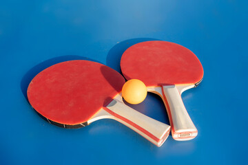 ping pong racket and ball on the blue table