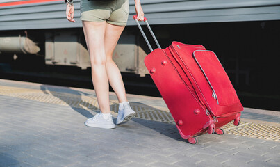 person pulling the baggage bag on the train station