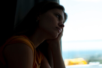 young female person looking in the window, depressed and despair feelings