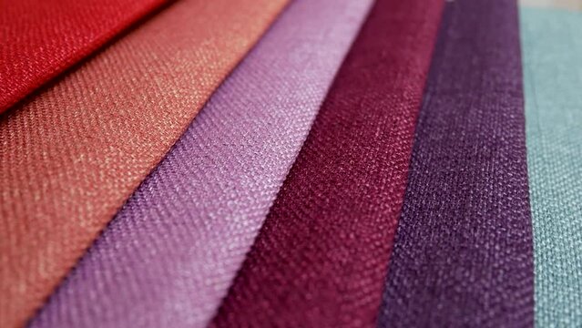 Textile textures fabric swatches. Fabric samples of different colors in move are spinning and rotation: from light orange to black color
