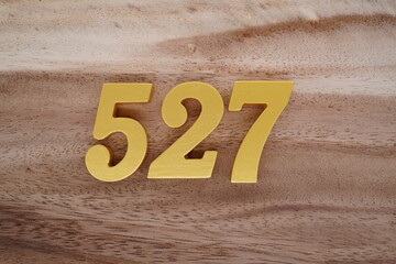 Golden Arabic numerals on a real brown and white wooden floor number 527