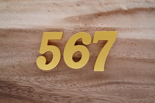 Golden Arabic numerals on a real brown and white wooden floor number 567