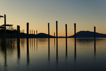 Fototapeta na wymiar Long exposure at clear lake at sunrise showing old boat docks