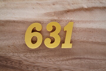 Golden Arabic numerals on a real brown and white wooden floor number 631