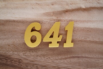 Golden Arabic numerals on a real brown and white wooden floor number 641