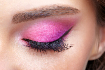 Obraz premium Closeup macro shot of closed human female eye. Girl with perfect skin and pink eyes shadows