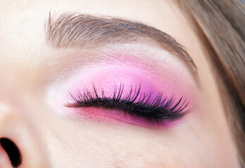 Obraz premium Closeup macro shot of closed human female eye. Girl with perfect skin and pink eyes shadows