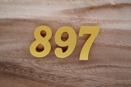 Golden Arabic numerals on a real brown and white wooden floor number 897