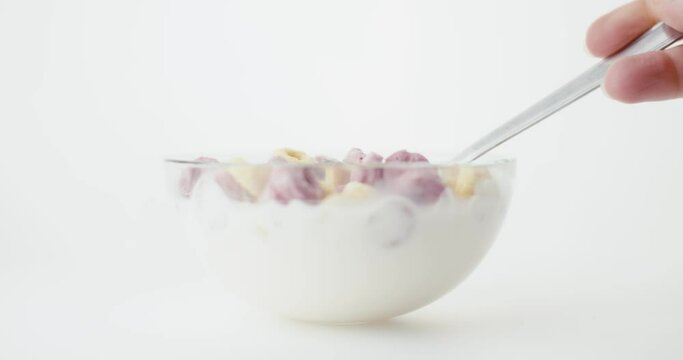 Cereal and milk glass bowl breakfast food slow motion spoon close up