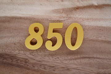 Golden Arabic numerals on a real brown and white wooden floor number 850