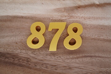 Golden Arabic numerals on a real brown and white wooden floor number 878