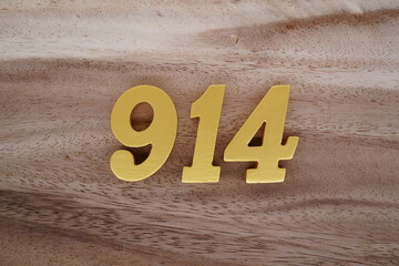 Golden Arabic numerals on a real brown and white wooden floor number 914