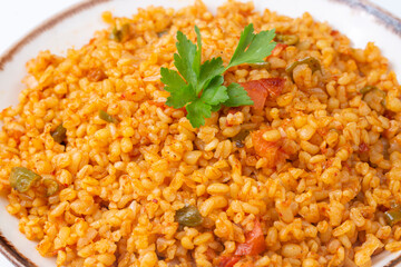 Traditional turkish bulgur pilaf with tomato sause in plate (Turkish name; meyhane pilavi)