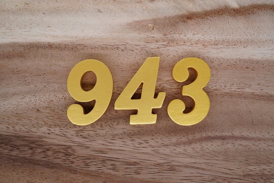 Golden Arabic numerals on a real brown and white wooden floor number 943