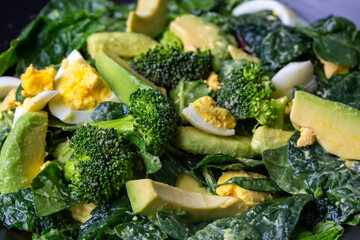 Avocado salad with broccoli, boiled egg in white vintage bowl on light salad