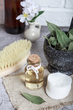 Laurel natural massage oil in a glass bottle. Cosmetic homemade tonic. Bay leaf in mortar with pestle