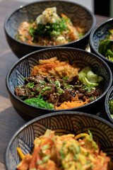 Poke bowls and other gourmet foods, with drinks and sushi on the table,