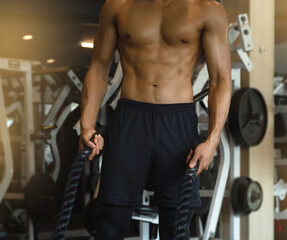 Fototapeta na wymiar Body of Young man with fit and firm muscle,holding black rope in hand .prepare for doing exercise,