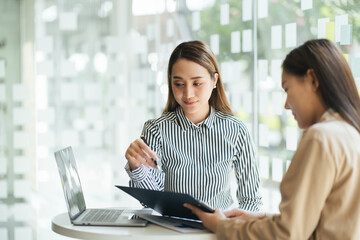 Businesswomen discussing project results and planning work in meeting room, female marketing or...