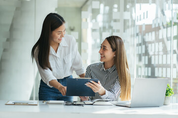 two young businesswoman wtih a clipboard discussing