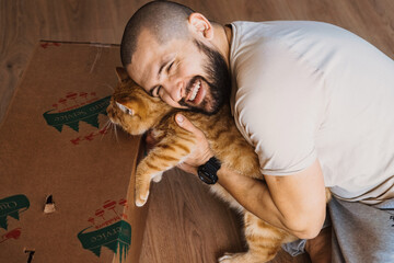 Man lovingly embracing purebred cat. True friendship between man and animal. Beautiful man embracing cat, great design for any purposes. Animal lover. Adorable