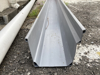 Close up of a PVC roof gutter on the ground, ready to be fix